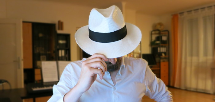 Der Autor mit weißem Hut in einem Zimmer.