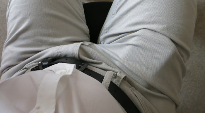 Rechteckige Ausbeulung am rechten Oberschenkel einer getragenen Hose.