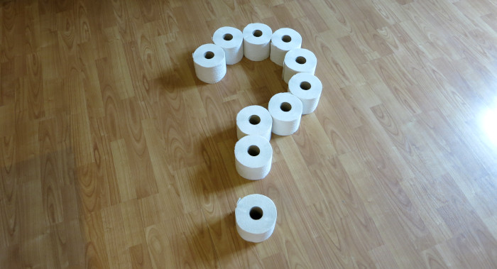 Zehn Rollen Toilettenpapier, angeordnet als Fragezeichen.