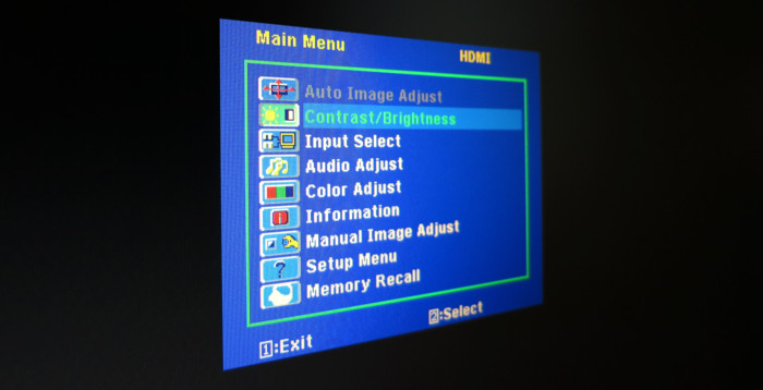 Monitormenü in kräftig gesättigten Farben, mit Menüpunkten wie »Contrast/Brightness« und »Input Select«.