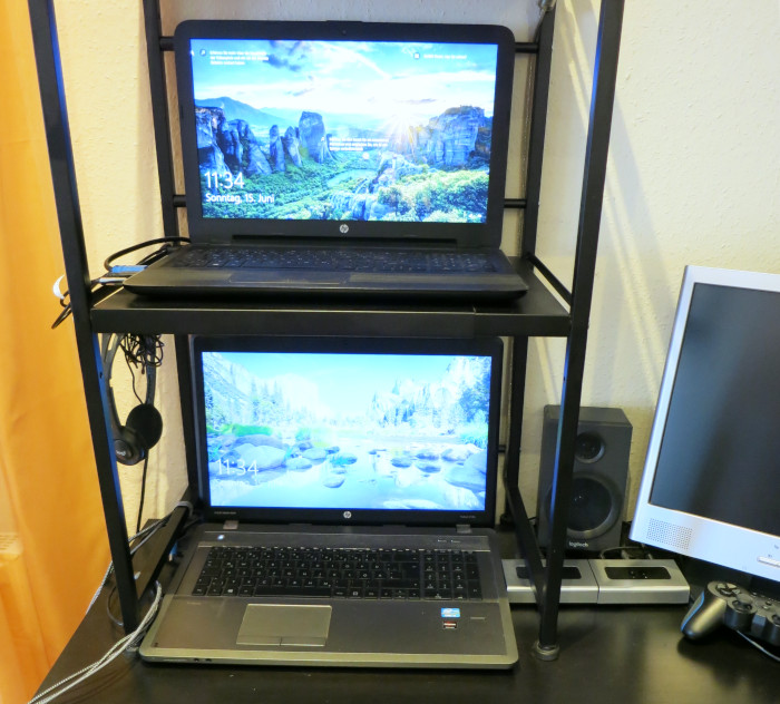 Zwei Laptops stehen übereinander in einem Regal.