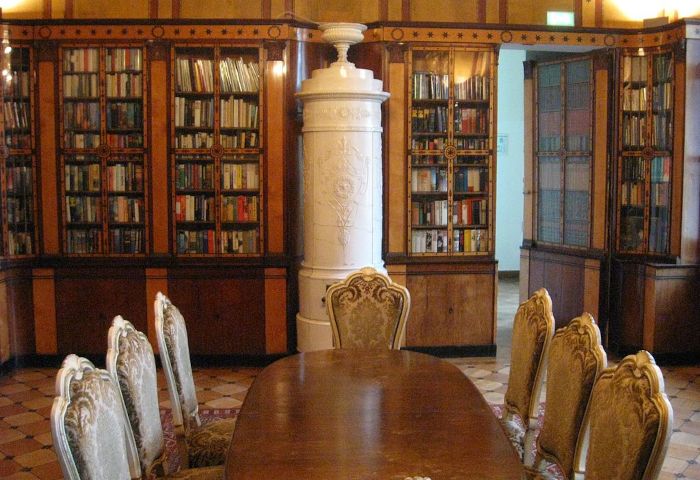 Bücherregal-Wand, in der ein Teil des Regals als Tür aufgekippt steht.