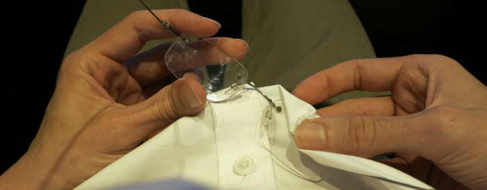 H&auml;nde putzen Brille mit derzeit getragenem Hemd.