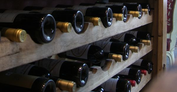 In Weinregal liegende Weinflaschen.