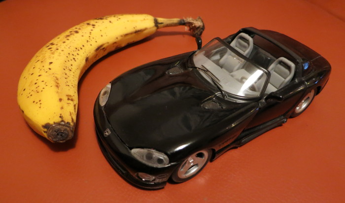 Schwarzer Sportwagen (Dodge Viper) neben einer Banane der selben Größe.