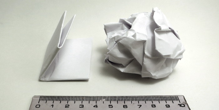 A4-Blatt gefaltet und A4-Blatt zerknüllt. Das zerknüllte Papier beansprucht deutlich mehr Volumen.