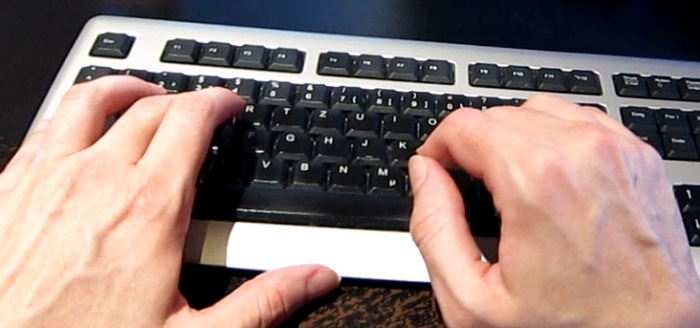 Zwei Hände auf einer Tastatur.