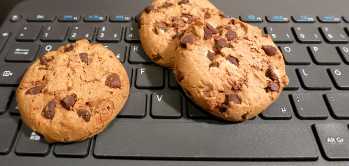 Kekse mit Schoko-Stückchen auf einer Tastatur.